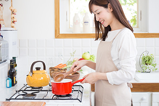 LPガスを使い料理している女性